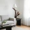 handcrafted-wooden-floor-lamp-with-shelves-there-is-a-couch-and-a-table-in-a-room